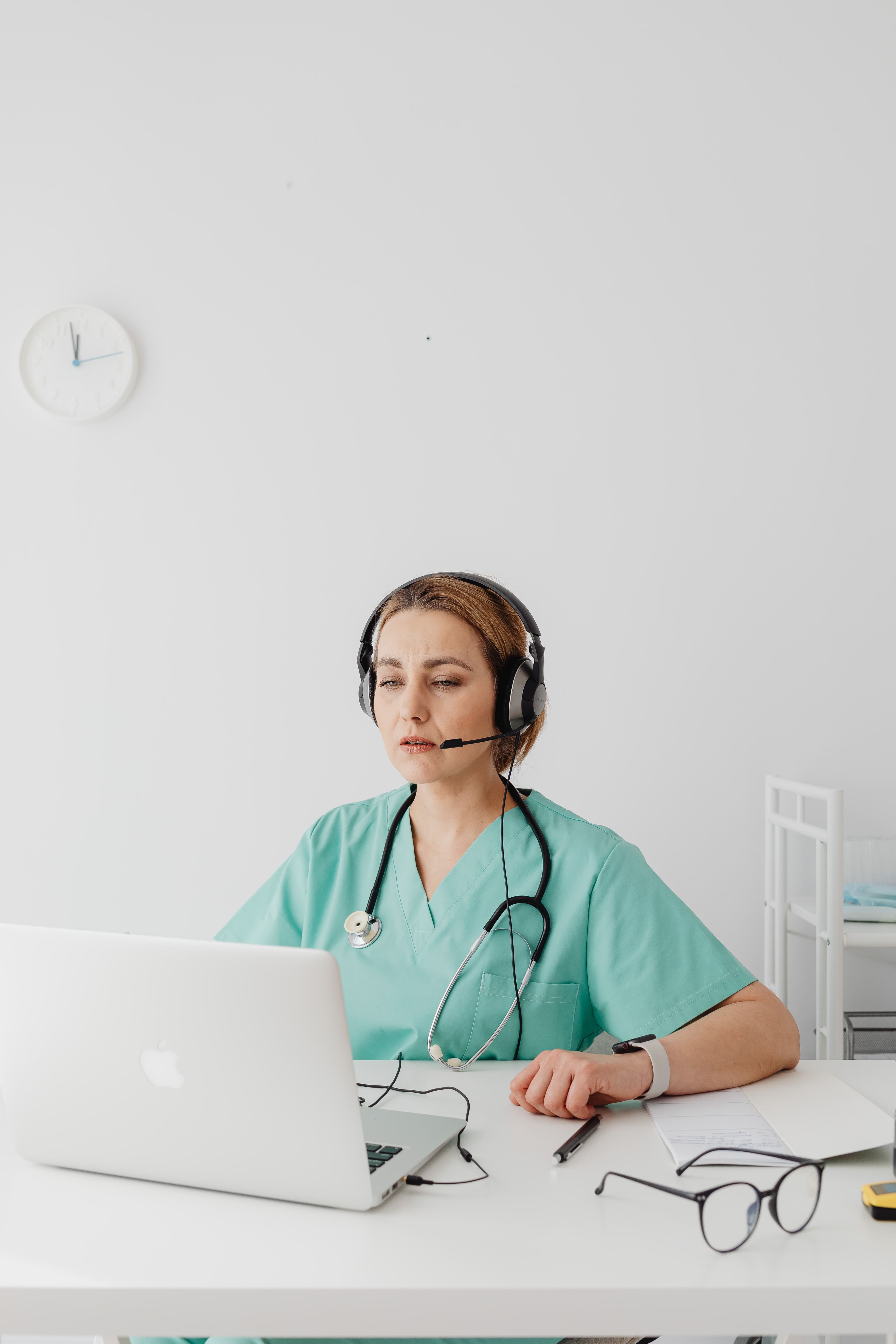 Telehealth practitioner wearing a headset and using a laptop